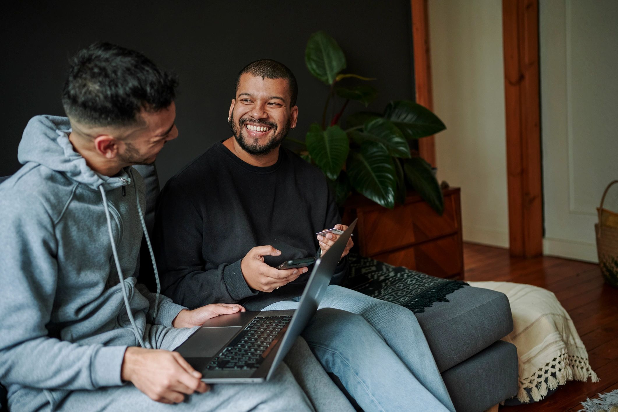 Friends relaxing on a couch while browsing listings online